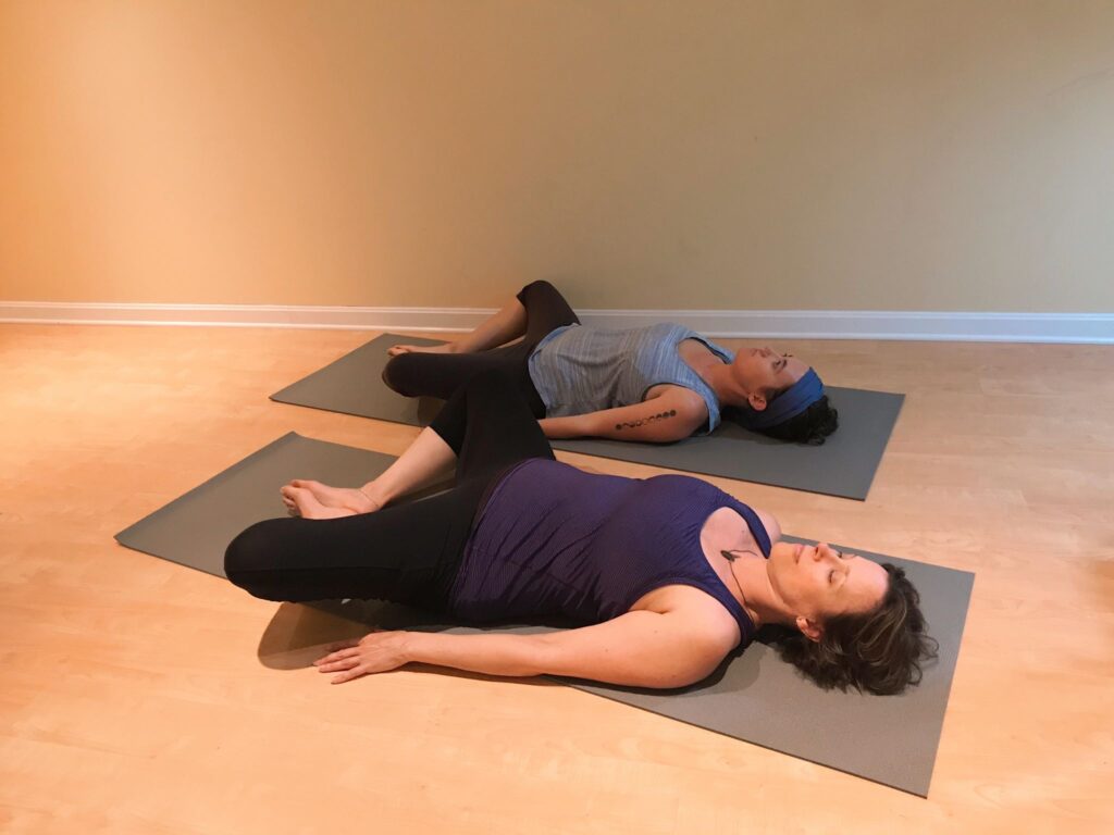 2 women laying in butterfly pose